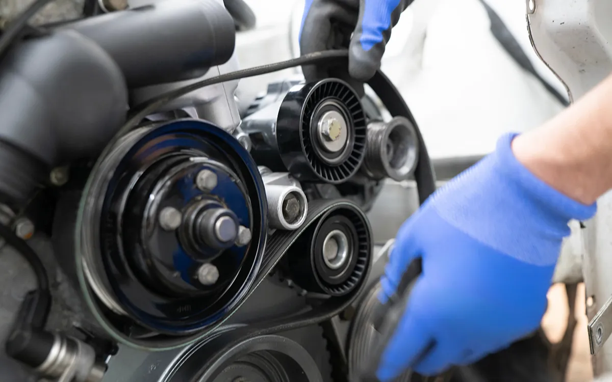 AMI MotorHub technician fitting a new cambelt and drive belt tensioner.