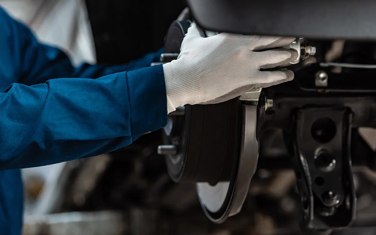 AMI MotorHub technician inspecting a brake disc and pad.